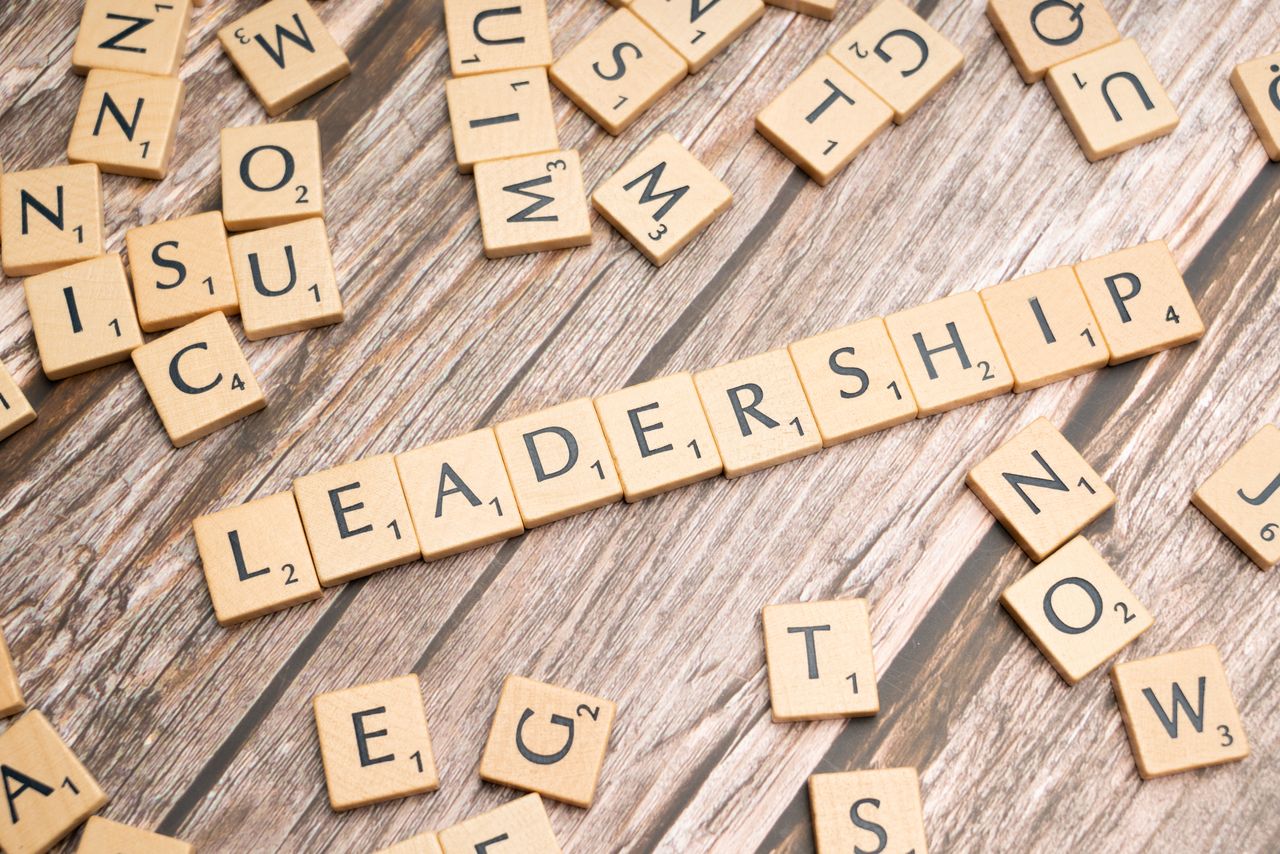 why-choose-us Wooden letter tiles spelling LEADERSHIP on a wooden surface, symbolizing leadership qualities and skills.